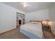 Neutral bedroom with a ceiling fan, wood frame bed, a closet with shelving, and a nightstand at 34 Normandy Rd, Evergreen, CO 80439