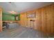 Spacious bedroom with wood paneling, carpeted floors, a ceiling fan, large windows, and a bed at 34 Normandy Rd, Evergreen, CO 80439