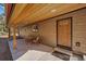 Relaxing covered patio with seating area and a view of the front yard at 34 Normandy Rd, Evergreen, CO 80439
