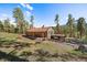 A cozy home nestled in a wooded area with a covered porch and deck for enjoying nature at 34 Normandy Rd, Evergreen, CO 80439