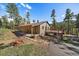 Charming exterior of a mountain home with a covered porch and spacious deck at 34 Normandy Rd, Evergreen, CO 80439