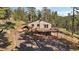 This mountain home is surrounded by trees and features a spacious deck at 34 Normandy Rd, Evergreen, CO 80439