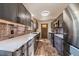 Stylish kitchen with gray cabinetry, brick backsplash, and stainless steel appliances at 34 Normandy Rd, Evergreen, CO 80439