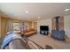 Spacious living room with a wood-burning stove and a comfortable leather sofa and natural lighting at 34 Normandy Rd, Evergreen, CO 80439