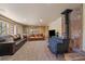 Cozy living room with a wood burning stove, two leather couches, lots of natural light, and carpeted floors at 34 Normandy Rd, Evergreen, CO 80439
