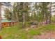 Shingled cabin surrounded by tall pine trees and natural vegetation and boulders at 184 Signal Rock Rd, Golden, CO 80403