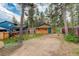 Wood sided cabin with a green door and trim and a large backyard full of native trees at 184 Signal Rock Rd, Golden, CO 80403