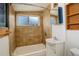 Cozy bathroom features a shower-tub combo, tile surround, and a window for natural light at 184 Signal Rock Rd, Golden, CO 80403