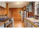 Kitchen with wood paneled walls, wooden floors, stainless steel appliances, and tile countertops at 184 Signal Rock Rd, Golden, CO 80403