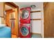 Convenient laundry area with stacked red washer and dryer, next to stainless steel refrigerator at 184 Signal Rock Rd, Golden, CO 80403
