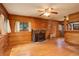 Living room featuring wood paneled walls, hardwood floors, a fireplace, and a ceiling fan at 184 Signal Rock Rd, Golden, CO 80403