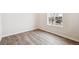 Bright bedroom with light wood floors, white walls, and a window overlooking the neighborhood at 1415 Orchard St, Brighton, CO 80601