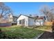 Backyard featuring green lawn and a building with a large sliding door, enclosed by a fence at 3073 S Elati St, Englewood, CO 80110