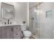 Modern bathroom with stylish vanity, toilet, and a glass-enclosed shower featuring gold fixtures at 3073 S Elati St, Englewood, CO 80110