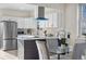 Bright eat-in kitchen boasts white cabinets, stainless steel appliances, and gray island at 3073 S Elati St, Englewood, CO 80110