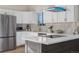 Well-lit kitchen features stainless appliances, white cabinets, and an island with seating at 3073 S Elati St, Englewood, CO 80110