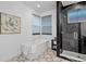 Modern bathroom showcasing standalone tub, mosaic tile floor, and a walk-in shower at 6052 N Malta St, Aurora, CO 80019