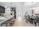Bright dining room showcases a glass table with seating and access to the modern kitchen with an island at 6052 N Malta St, Aurora, CO 80019