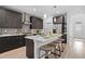Modern kitchen features dark cabinets, stainless steel appliances, gray backsplash, and a quartz countertop island with seating at 6052 N Malta St, Aurora, CO 80019