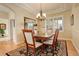 Elegant dining room with wood floors, classic chandelier, and large window with shutters at 15004 Verbena St, Thornton, CO 80602