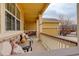 Cozy covered front porch with comfortable seating area and decorative stone accents at 15004 Verbena St, Thornton, CO 80602