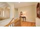 Upstairs hallway featuring hardwood floors and a view of a decorative table at 15004 Verbena St, Thornton, CO 80602