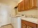 Functional laundry room with a washer, dryer, cabinets, sink, and access to the outside at 15004 Verbena St, Thornton, CO 80602