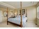 Comfortable main bedroom with a four-poster bed, ensuite bathroom, and neutral color palette at 15004 Verbena St, Thornton, CO 80602