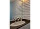 Bathroom featuring a vanity with a sink, a large mirror, and a white painted brick accent wall at 1060 S Parker Rd # 9, Denver, CO 80231