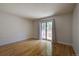 Sunlit bedroom with hardwood floors, white brick wall, and sliding glass doors with security bars at 1060 S Parker Rd # 9, Denver, CO 80231