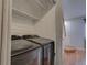 Convenient laundry area featuring modern Samsung washer and dryer units, shelving, and access to stairs at 1060 S Parker Rd # 9, Denver, CO 80231