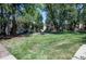 A large green lawn is surrounded by trees and a warm toned condo complex at 1060 S Parker Rd # 9, Denver, CO 80231