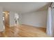 Open living room showcasing gleaming hardwood floors, a brick accent wall, and an adjacent kitchen at 1060 S Parker Rd # 9, Denver, CO 80231