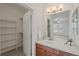 Bright bathroom with a wood vanity, sink, and large mirror; also contains a closet for storage at 9907 Martin Luther King Blvd # 103, Denver, CO 80238