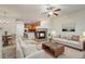 Inviting living room featuring a fireplace, ceiling fan, and open floorplan with natural light at 9907 Martin Luther King Blvd # 103, Denver, CO 80238