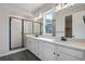 Bathroom featuring double sinks, shower, tiled floor, and a window at 17831 Parkside N Dr, Commerce City, CO 80022