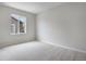 Light-filled bedroom with neutral walls, carpet, and a view from the window at 17831 Parkside N Dr, Commerce City, CO 80022