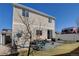 A two-story home showcasing a patio area, lush green lawn, and vinyl siding at 21088 Randolph Pl, Denver, CO 80249