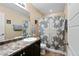 A full bathroom featuring a shower with patterned curtain, a sink, and dark wood vanity with a neutral toned wall at 21088 Randolph Pl, Denver, CO 80249