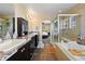 Bathroom featuring a soaking tub, tiled shower, double vanity with dark cabinets and an archway to the main bedroom at 21088 Randolph Pl, Denver, CO 80249