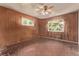 Bedroom with wood paneled walls, a ceiling fan, and windows offering natural light at 1000 Salem St, Aurora, CO 80011