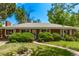 Charming single-story brick home with mature trees and a well-maintained front yard on a sunny day at 1000 Salem St, Aurora, CO 80011
