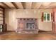 Living room featuring brick fireplace, wood beamed ceiling, and natural light from the window at 1000 Salem St, Aurora, CO 80011