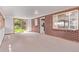 Spacious living room with brick accent wall, large window, and sliding glass doors to the backyard at 1000 Salem St, Aurora, CO 80011