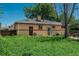 A cozy brick home with a backyard featuring an overgrown garden and a covered chimney at 10839 Carrol Ln, Northglenn, CO 80233