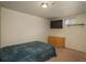 Cozy basement bedroom with small window, carpet flooring, dresser, and tv at 10839 Carrol Ln, Northglenn, CO 80233