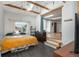 Bedroom with a bed, exposed wood beams, skylights and a doorway to a living area at 10839 Carrol Ln, Northglenn, CO 80233