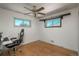 Bright bedroom with hardwood floors, two windows, and a gaming chair at 10839 Carrol Ln, Northglenn, CO 80233