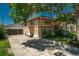 A single story home with brick exterior, driveway, and mature shade tree at 10839 Carrol Ln, Northglenn, CO 80233