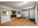 Open living room with hardwood floors, skylights, and modern decor flows to a kitchen with stainless steel appliances at 10839 Carrol Ln, Northglenn, CO 80233